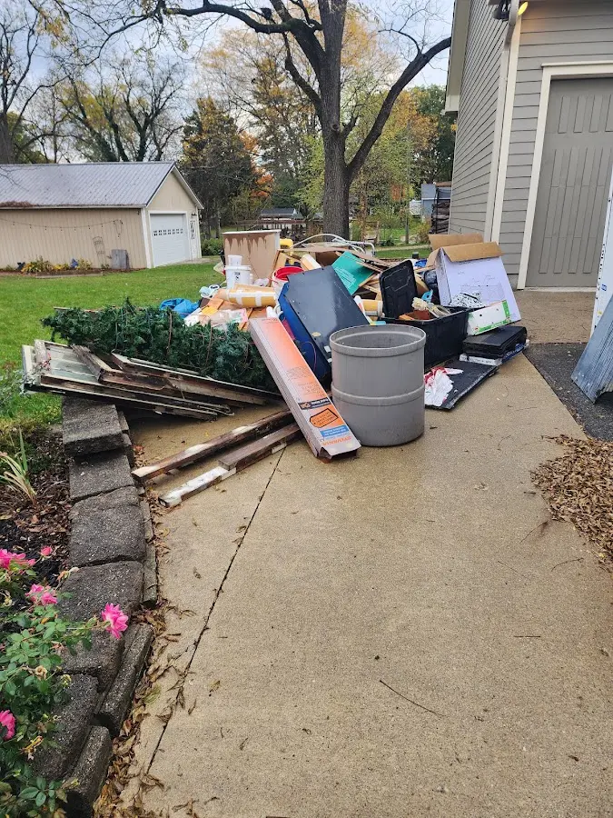 Dumpster being loaded with debris for Estate Cleanout Dumpster Rental in Forest Lake